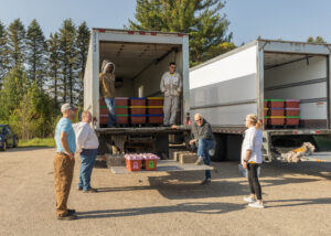 Great Lakes Bee Company volunteers unload cases of bees for 2025 pickup